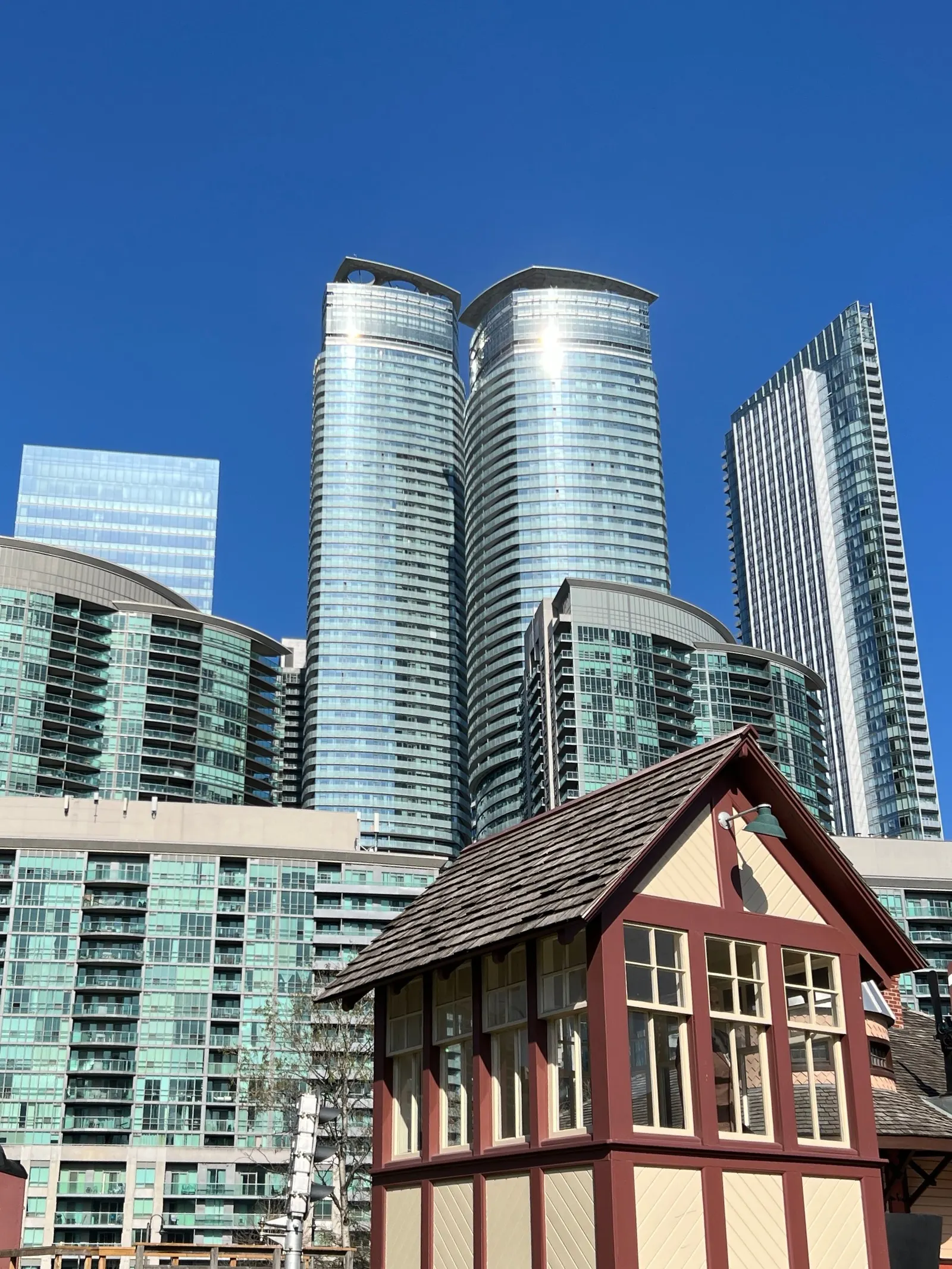 Curved glass condominium towers on the Toronto harbourfront under a pale sky